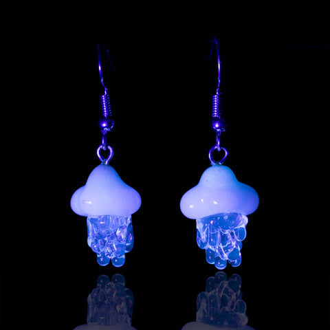 A set of purple rain dangle earrings under UV light showcasing the UV blue glow of the rain.