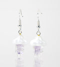 A pair of purple rain themed dangle earrings made of glass. The pieces feature purple colored rain falling from a white cloud. Attached to the cloud are sterling silver earring backings.