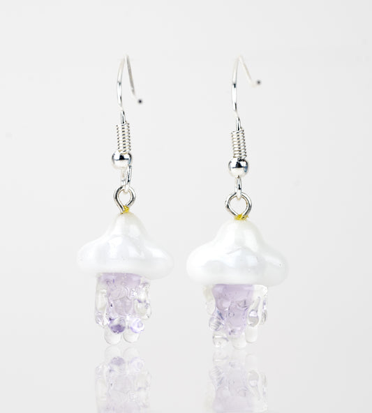 A pair of purple rain themed dangle earrings made of glass. The pieces feature purple colored rain falling from a white cloud. Attached to the cloud are sterling silver earring backings.