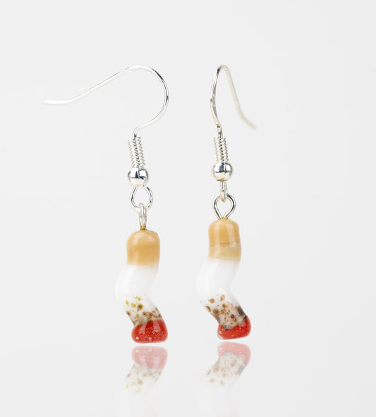 A set of two crushed cigarette themed dangle earrings. Each cig is made of glass with a red, burnt bottom, a white middle section, and a brown filter. Above each cigarette is a sterling silver earring hook.  