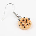Close-up of milk and cookie earrings on white background