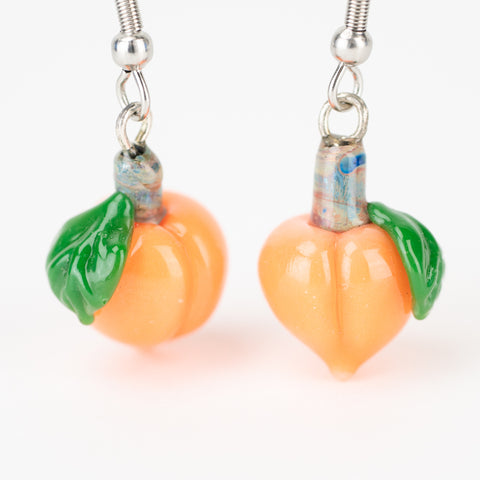 Handmade pink-orange peach earrings on white background